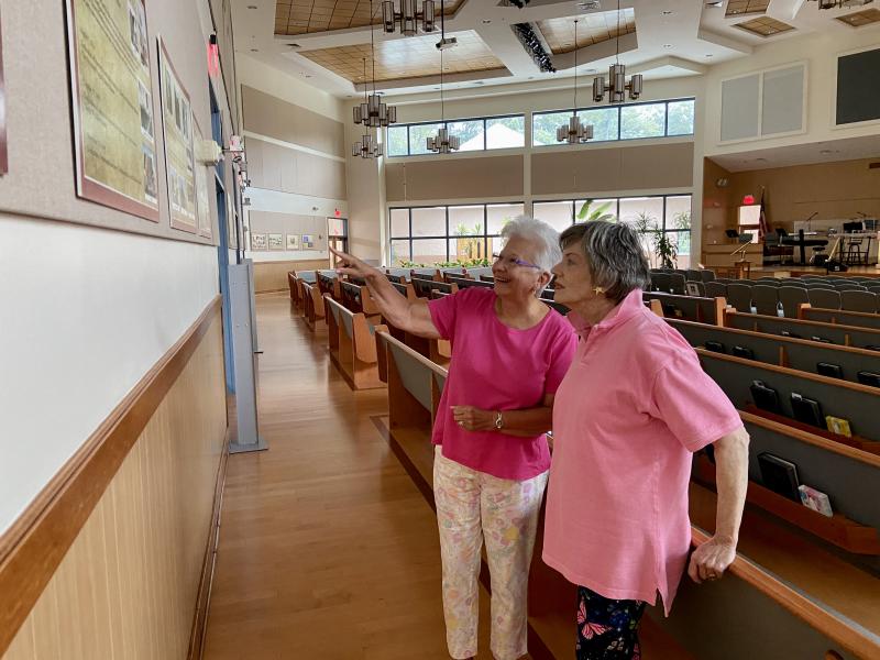 Epworth United Methodist Church members Susan Jimenez, left, and Suzanne Landon point out interesting facts on the church’s history wall. The two are part of a group planning the church’s 125th anniversary celebration set for Sept. 17-18. ELLEN DRISCOLL PHOTOS